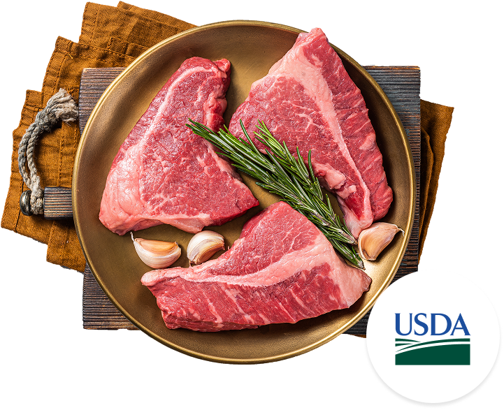 Raw meat cuts on a wooden board with onions, tomatoes, and radishes, illustrating Farm-Fresh Sourcing With Full Transparency.