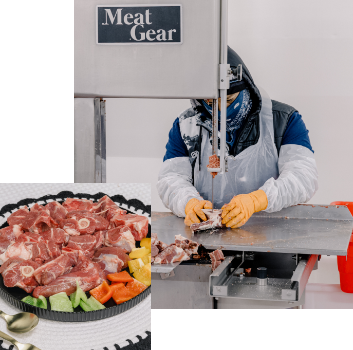 Halal meat worker cutting fresh meat in a USDA-inspected processing facility with a plate of prepared lamb and vegetables displayed beside the workstation.