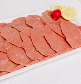 Slices of raw Beef Tongue on a white tray, garnished with lemon and radish.